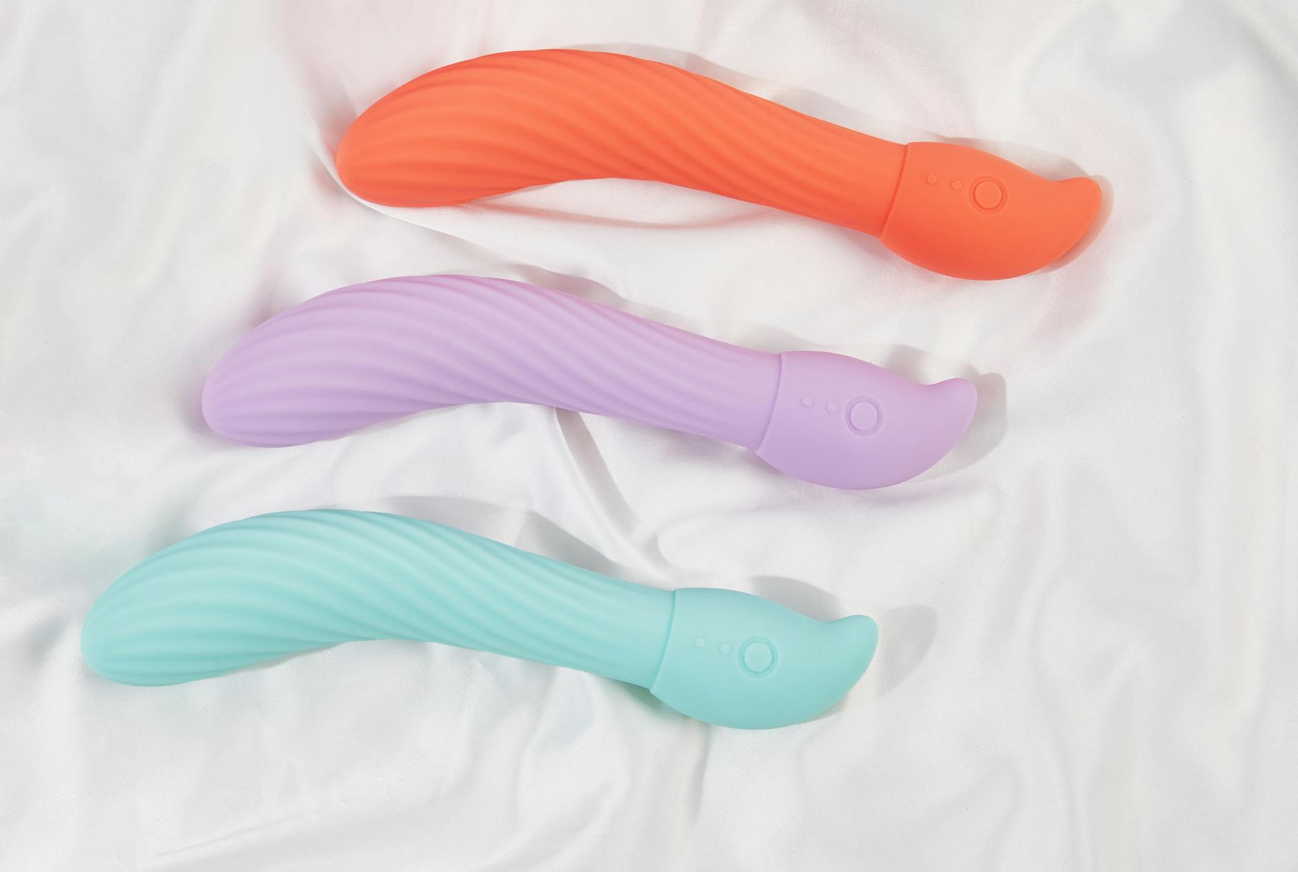 Three colorful lemon vibrators arranged on white fabric, showcasing smooth texture and design