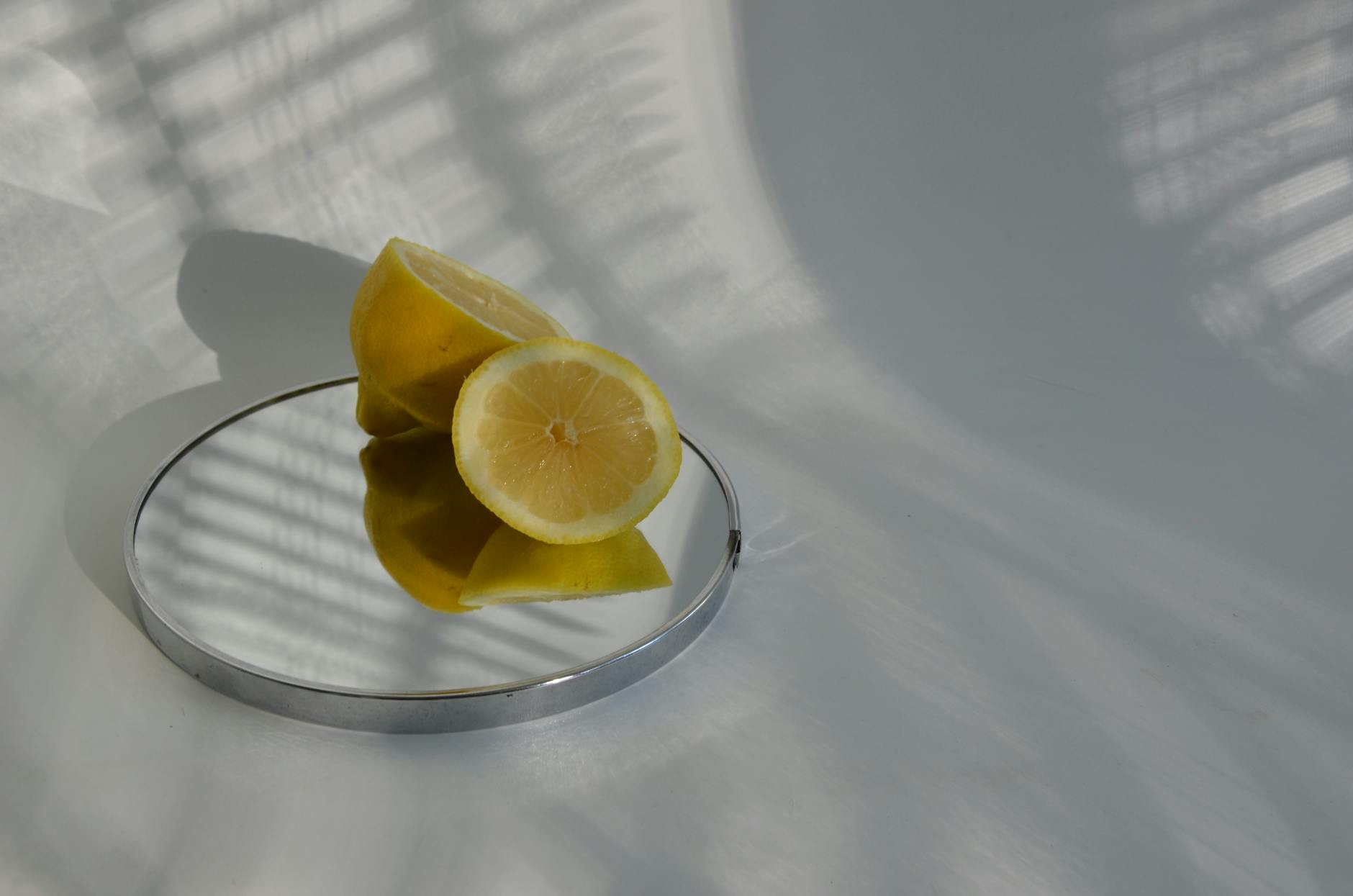 Blue vibrator surrounded by flowers and citrus slices on a bright yellow background