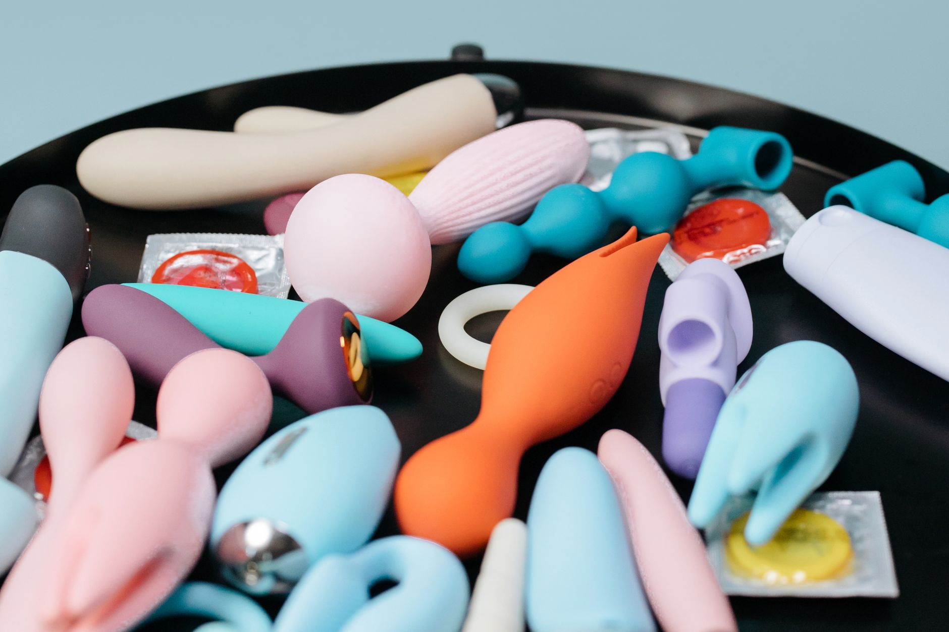 A vibrant collection of various lemon sexual toys and vibrators on a black tray