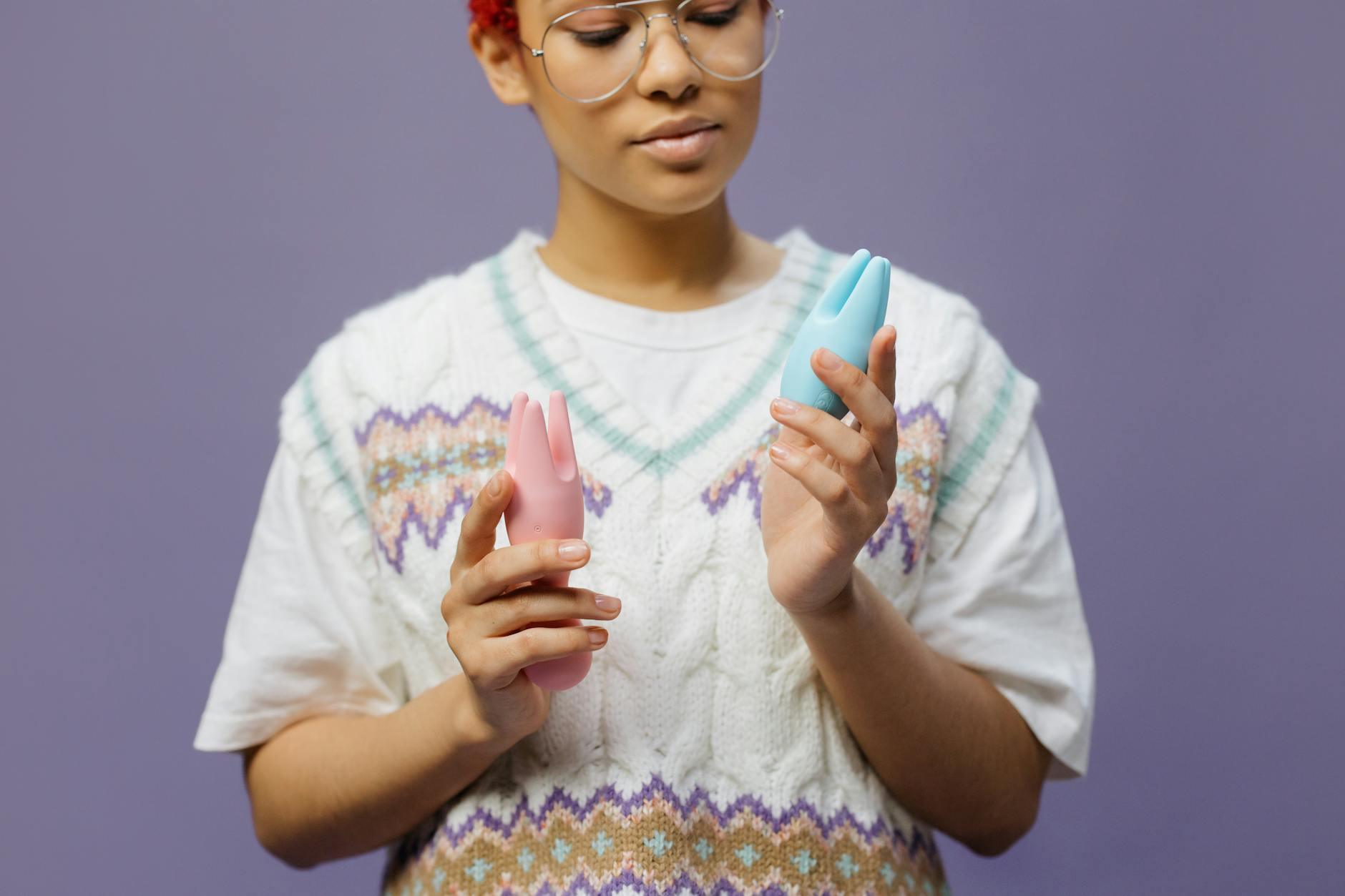 Woman holding colorful vibrators demonstrating different pleasure toy options