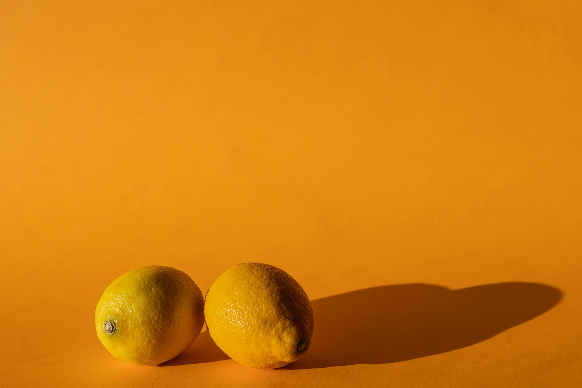 Bright yellow lemons on a yellow background, symbolizing the energizing effect of restored pleasure